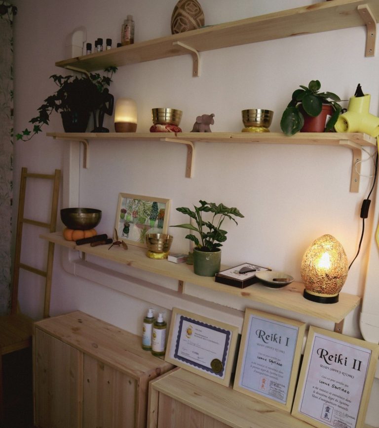 Étagères en bois avec plantes, lampes, certificats et produits sur un meuble en bois.