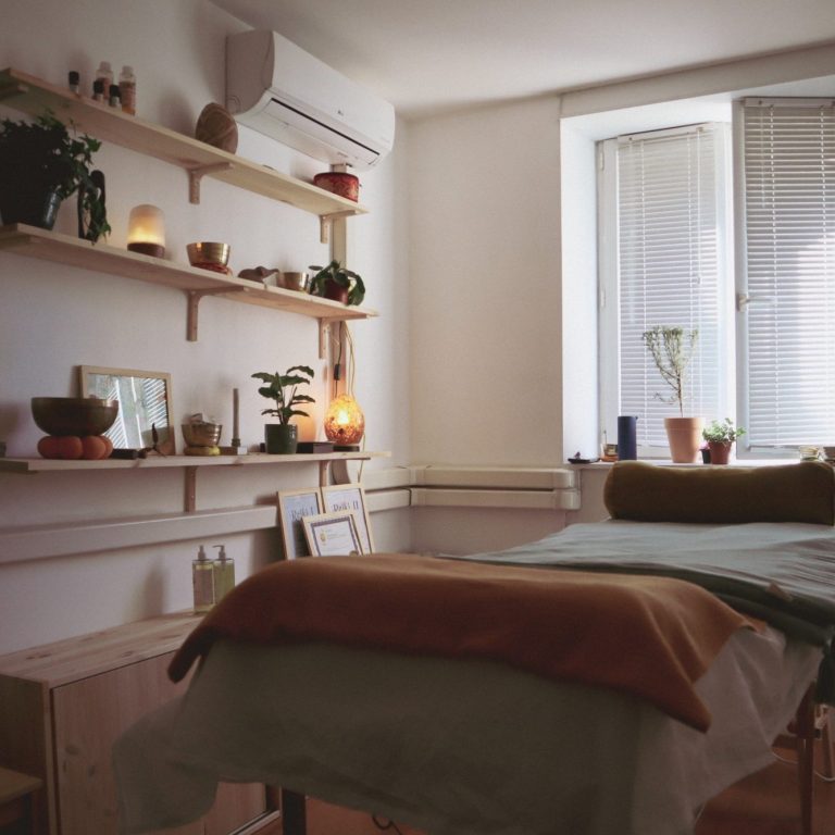 Salle de soins apaisante avec lits, plantes et éclairage doux.